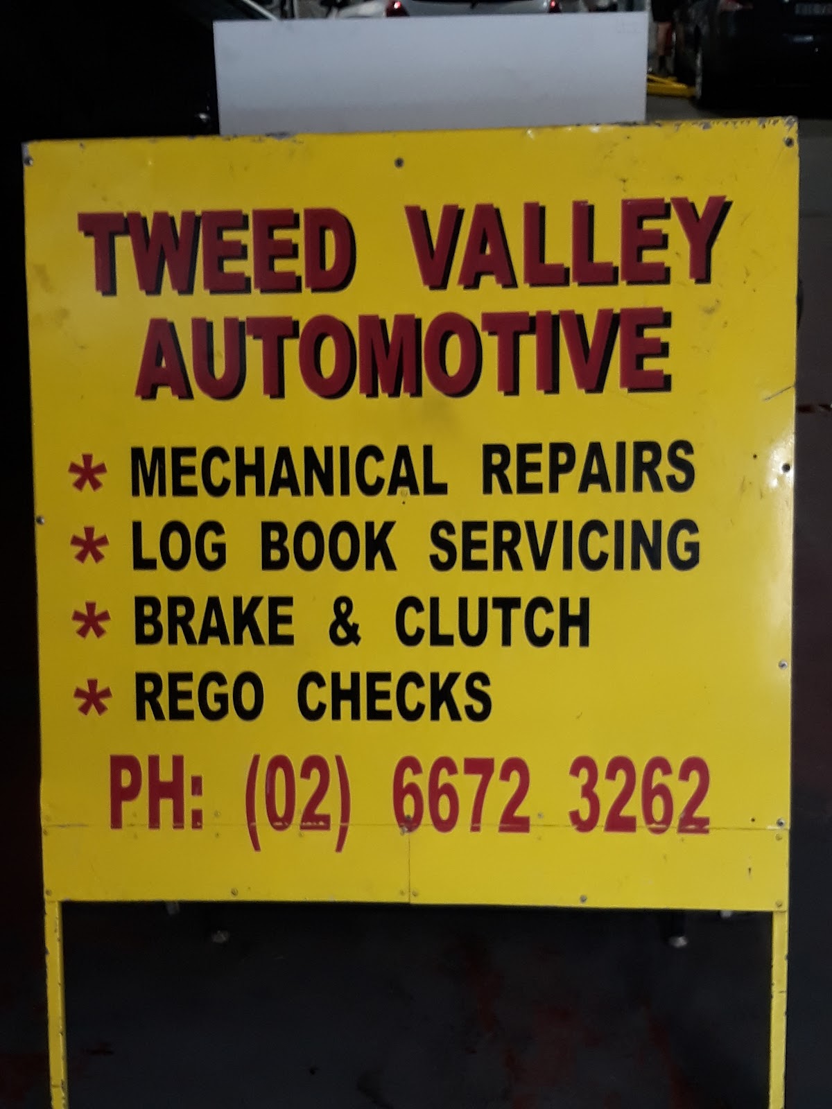 Yellow Tweed Valley Automotive sign listing mechanical repairs, log book servicing, brake and clutch, and rego checks