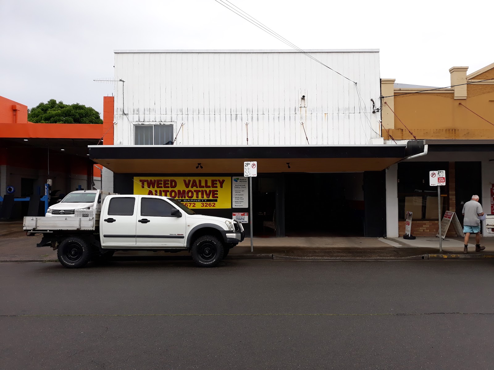 Wide view of the white building on Prospero St with the old yellow Tweed Valley Automotive sign